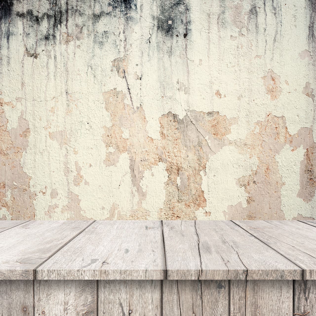 A wooden table with a white wall behind it